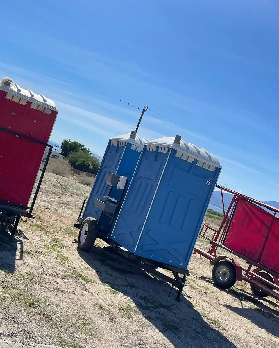 Towable porta potty trailers parked on open ground